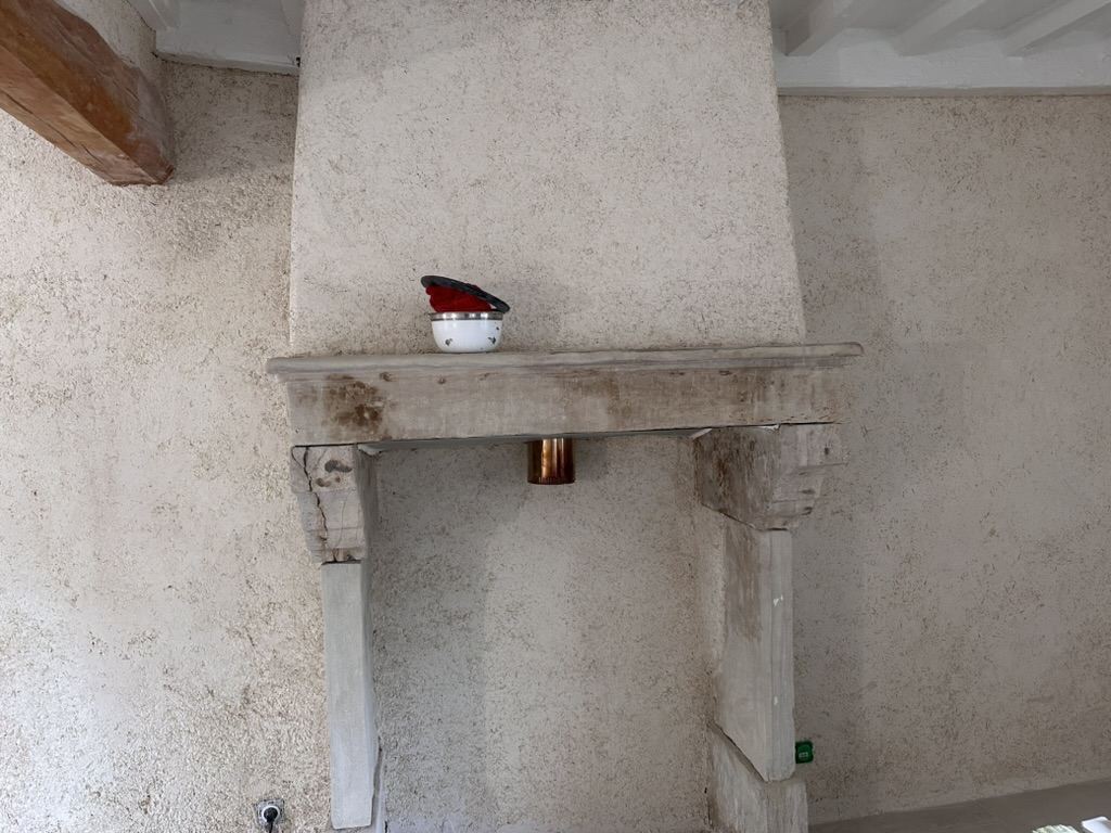 Cheminée en pierre conservée au milieu du chaux-chanvre
