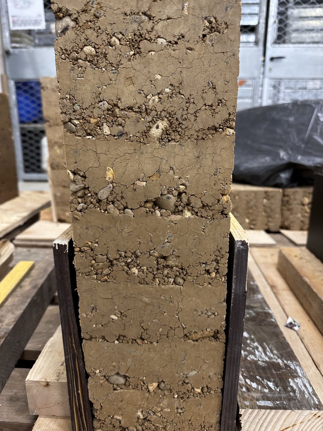 Blocs de pisé empilés sur un plateau d'atelier